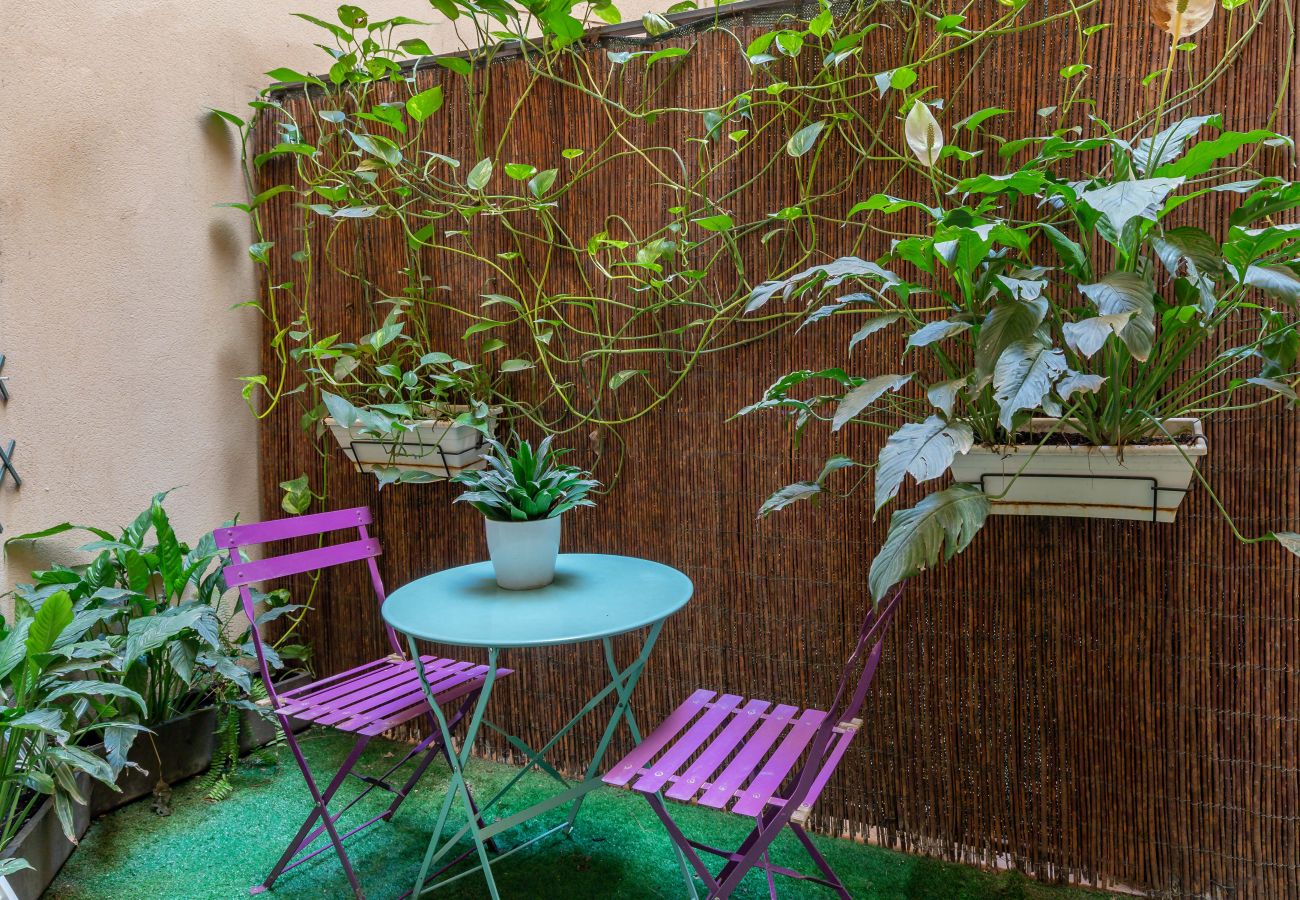 Mesa y sillas de terraza rodeadas de plantas en ApartUP Valencia